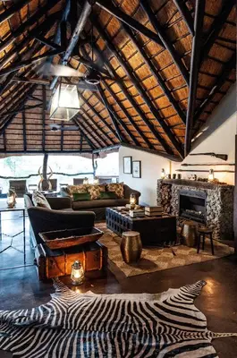 a living room with a couch and a fireplace at Jock Safari Lodge in Skukuza