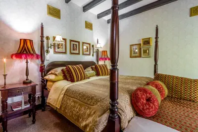 a bedroom with a bed and a table and lamps at Kilmorna Manor Guest House in Schoemanskloof