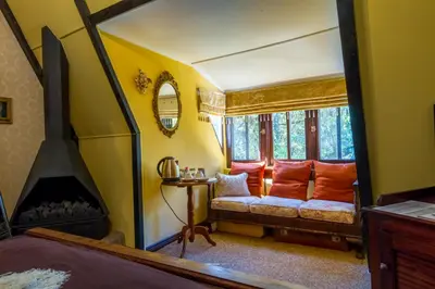 a yellow room with a couch and a window at Kilmorna Manor Guest House in Schoemanskloof