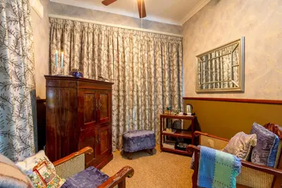a living room with a couch and a curtain at Kilmorna Manor Guest House in Schoemanskloof