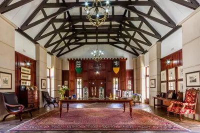 a large room with a table and a chandelier at Kilmorna Manor Guest House in Schoemanskloof