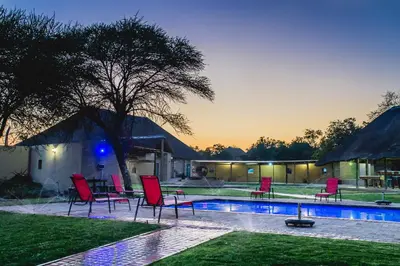 a group of chairs next to a swimming pool at Ritsako Game Lodge in Klipdrift