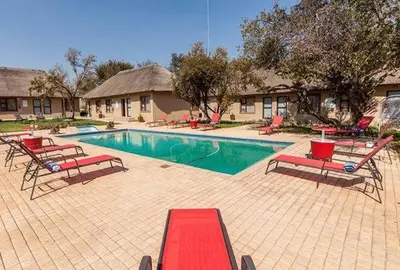 a pool with chaise lounges and chairs in a resort at Ritsako Game Lodge in Klipdrift