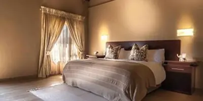 a bedroom with a large bed and a window at Ritsako Game Lodge in Klipdrift