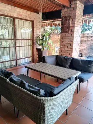 a living room with a table and a couch at Mamli Guestlodge & Conferencing in Schoemansdal