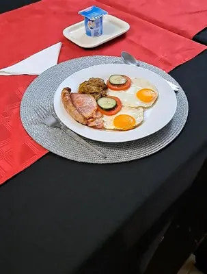 a plate of eggs and sausage on a table at Mamli Guestlodge & Conferencing in Schoemansdal