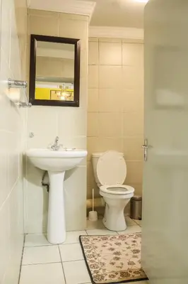 a bathroom with a toilet and a sink at Mamli Guestlodge & Conferencing in Schoemansdal