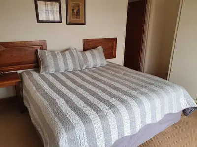 a bed with a striped comforter in a bedroom at Blyde Canyon, A Forever Resort in Matibidi