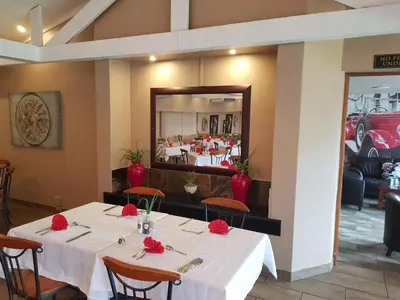 a dining room with a table with red roses on it at Blyde Canyon, A Forever Resort in Matibidi