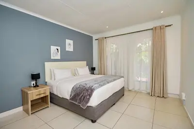 a bedroom with a large bed and a window at Menlyn Maine: The Exquisite Lunette in Pretoria
