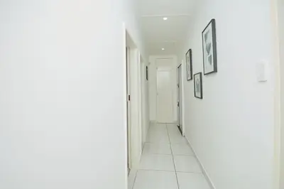 a hallway with white walls and pictures on the walls at Menlyn Maine: The Exquisite Lunette in Pretoria