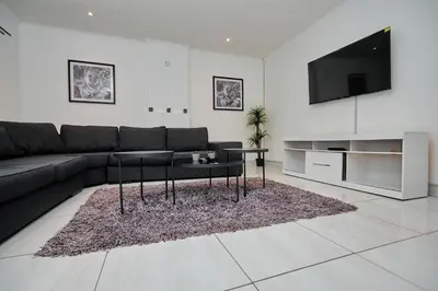 a living room with a couch and a tv at Menlyn Maine: The Exquisite Lunette in Pretoria