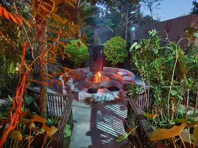 a patio with a fire pit in a garden at Dar Amane Guest House in Graskop