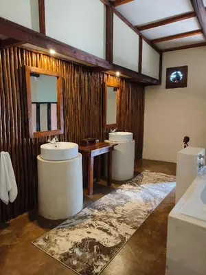 a bathroom with two sinks and two mirrors at Dar Amane Guest House in Graskop