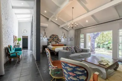 a living room with a bed and a couch at La Roca Guest House in Nelspruit