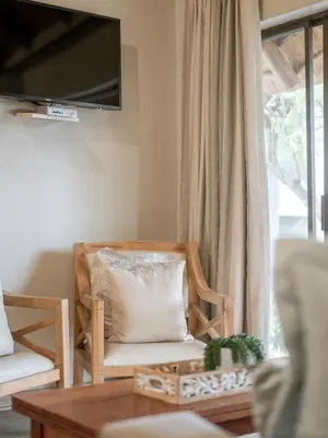 a living room with a chair and a television at La Roca Guest House in Nelspruit