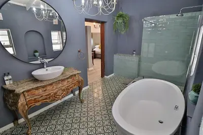 a bathroom with a toilet and a sink and a mirror at La Roca Guest House in Nelspruit