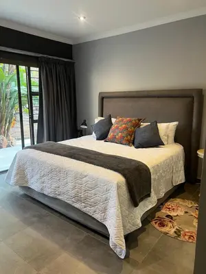 a bedroom with a large bed with pillows at Koru Guesthouse in Pretoria