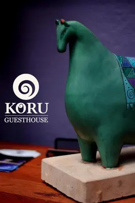 a green cat statue sitting on top of a table at Koru Guesthouse in Pretoria