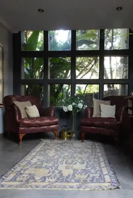 a living room with two couches and a large window at Koru Guesthouse in Pretoria