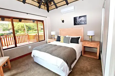 a bedroom with a bed and a balcony at Kruger Park Lodge Unit No. 509 in Hazyview