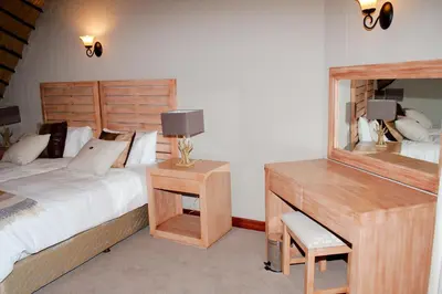 a bedroom with a bed and a desk with a bed sidx sidx sidx at Kruger Park Lodge Unit No. 509 in Hazyview