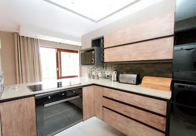 a kitchen with white counter tops and wooden cabinets at Kruger Park Lodge Unit No. 509 in Hazyview