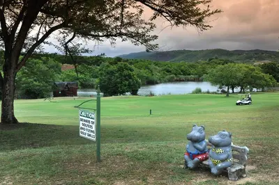 two stuffed animals sitting next to a sign on a golf course at Kruger Park Lodge Unit No. 509 in Hazyview