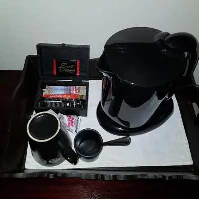 a black tea pot and cups on a tray at Falling Feather Inn in Pretoria