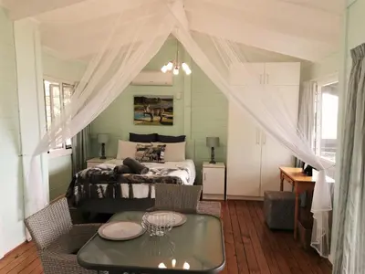 a bedroom with a bed and a table in a room at Kruger View Tree House in Marloth Park