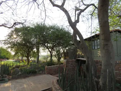 a house with a fence in front of a yard at Kruger View Tree House in Marloth Park