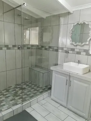 a bathroom with a shower and a sink and a mirror at Kruger View Tree House in Marloth Park