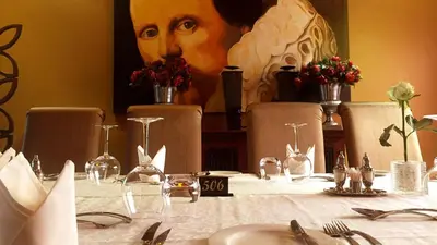 a table with a picture of a woman on the wall at Fusion Boutique Hotel in Polokwane