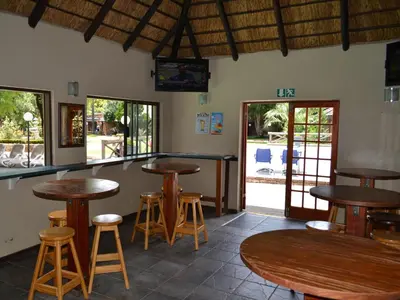 a bar with wooden tables and stools in a restaurant at Mount Amanzi in Hartbeespoort