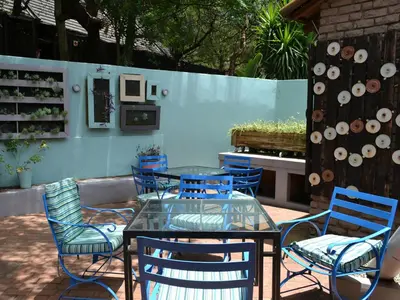 a patio with a glass table and chairs at Mount Amanzi in Hartbeespoort