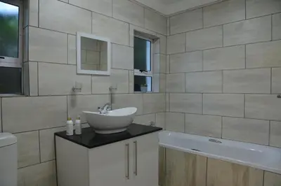 a bathroom with a sink and a bath tub at The Shore House in Hartbeespoort