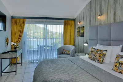 a bedroom with a bed and a chair and a window at The Shore House in Hartbeespoort