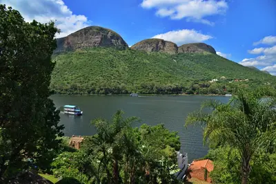 a boat on a river in front of mountains at The Shore House in Hartbeespoort