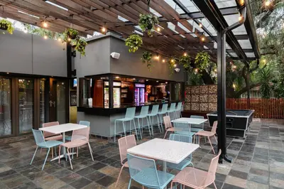 a restaurant with tables and chairs and a bar at Hotel 224 & Apartments in Pretoria