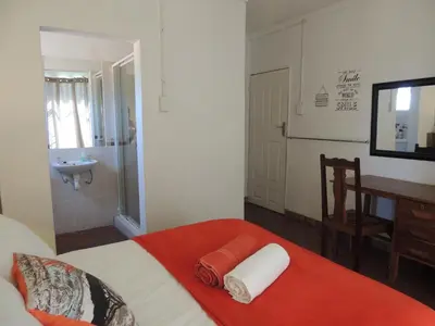 a bedroom with a bed and a bathroom with a sink at Karibu River Retreat in Marble Hall