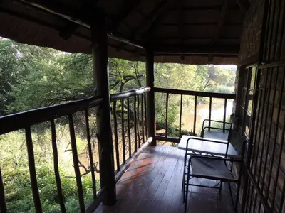 a porch of a house with two chairs on it at Karibu River Retreat in Marble Hall