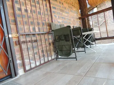 a group of chairs in a room with a brick wall at Karibu River Retreat in Marble Hall