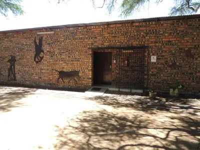 a brick building with a door with a deer painted on it at Karibu River Retreat in Marble Hall