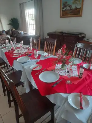 a dining room with a table with a red table cloth at Karibu River Retreat in Marble Hall
