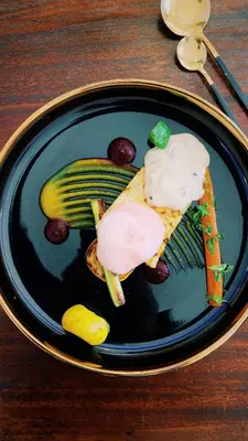 a plate of food with a sandwich and a pickle at Ledumo Guest lodge in Witbank