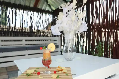 a table with a vase of flowers and a drink at Ledumo Guest lodge in Witbank