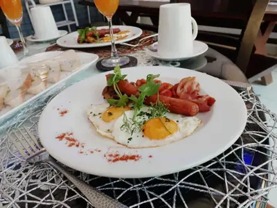 a plate of food with eggs and sausage on a table at Ledumo Guest lodge in Witbank