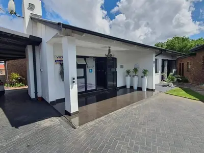 a large white house with a driveway at Ledumo Guest lodge in Witbank
