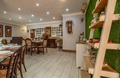 a dining room and living room with green walls at Diamond Rose Guest House in Middelburg