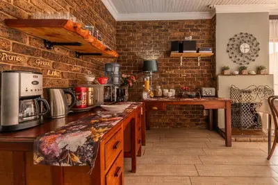 a kitchen with a brick wall and a counter top at Diamond Rose Guest House in Middelburg